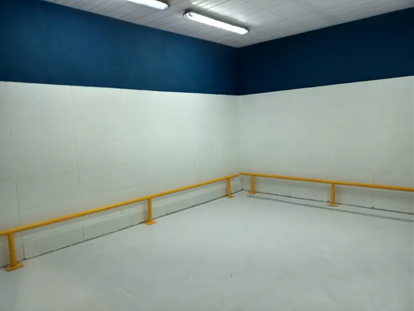 Galpão com pintura em dois tons e guarda-corpo amarelo instalado