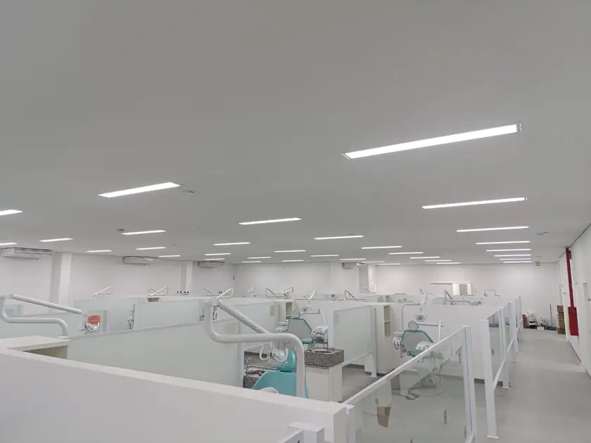 Área ampla de clínica com boxes e iluminação instalada